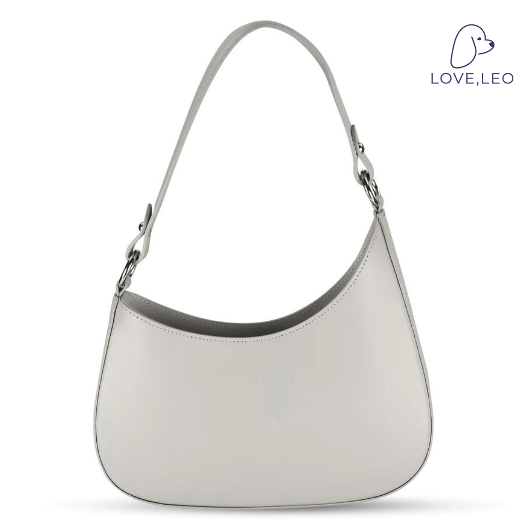 Our structured Angelina bag is a chic addition to any outfit, and features genuine Italian leather, an asymmetrical silhouette, a shoulder strap, and a top zipper. Shoulder strap, top zipper, inside pocket. 100% Italian leather. Spot clean. Made in Italy.