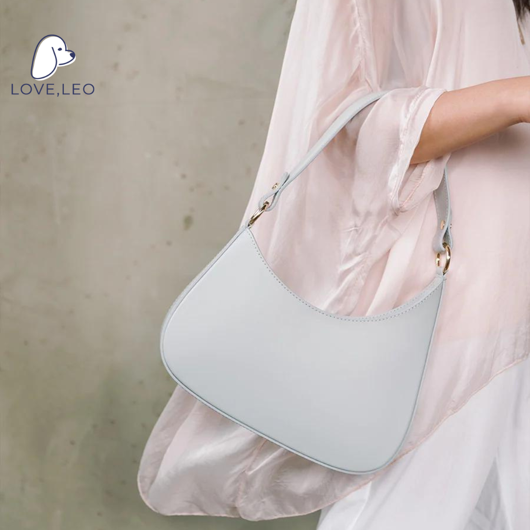 Our structured Angelina bag is a chic addition to any outfit, and features genuine Italian leather, an asymmetrical silhouette, a shoulder strap, and a top zipper. Shoulder strap, top zipper, inside pocket. 100% Italian leather. Spot clean. Made in Italy.
